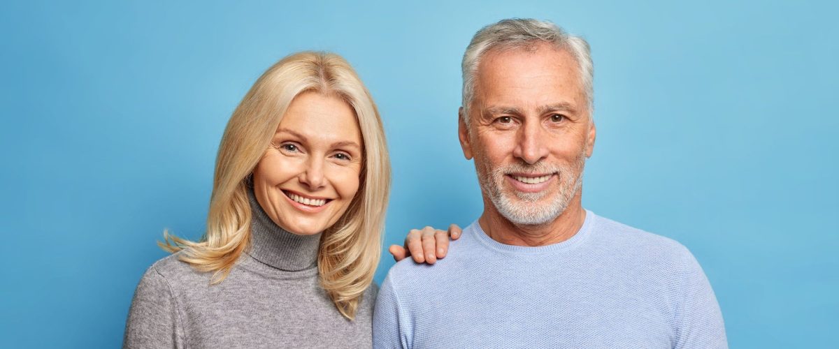 Photo of happy senior woman and man express positive emotions pose together being still in love isolated over blue background. Smiling grandmother grandfather make family photo glad to meet children Photo of happy senior woman and man express positive emotions pose together being still in love isolated over blue background. Smiling grandmother grandfather make family photo glad to meet children